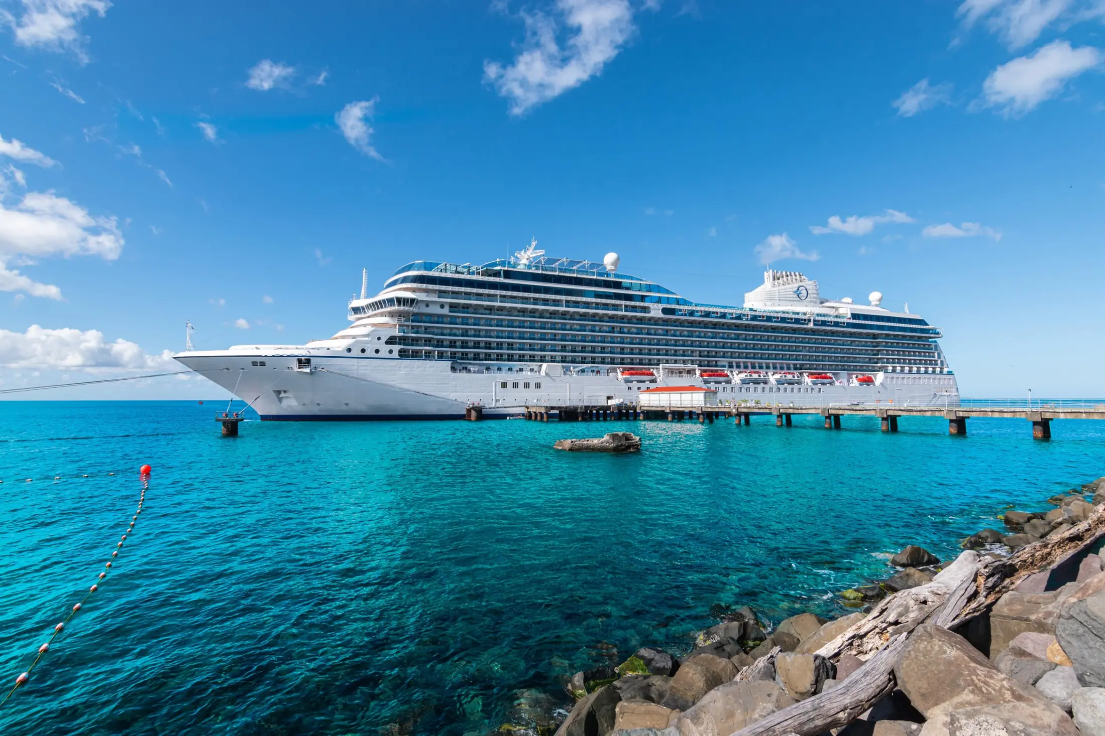 Oceania Allura docked in bright Caribbean water