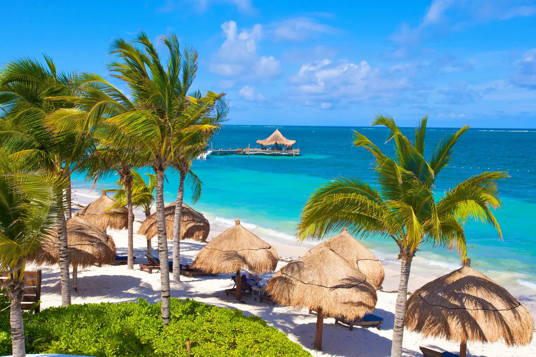 White-sand beach and turquoise Caribbean water at Desire Pearl Riviera Maya